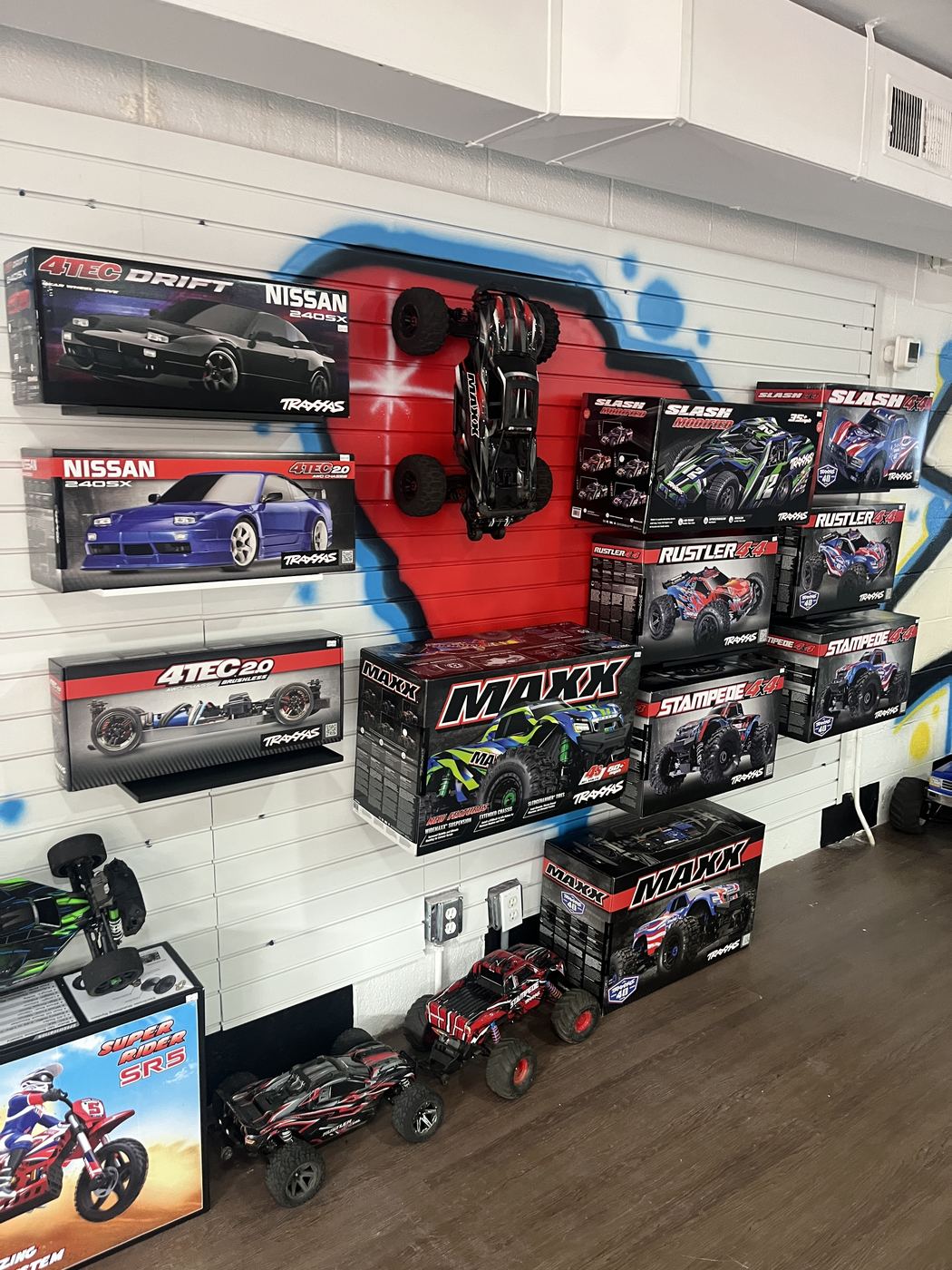 Traxxas drift cars and Maxx monster trucks on the wall at SC2NY RC Shop