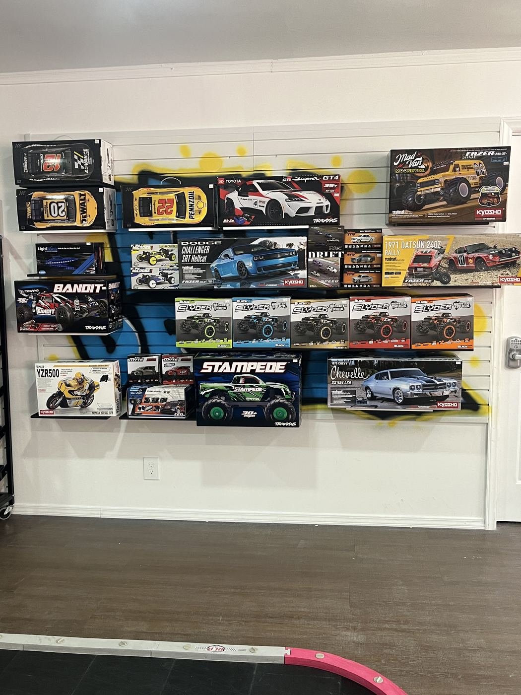 RC cars and trucks on display next to the indoor track at SC2NY